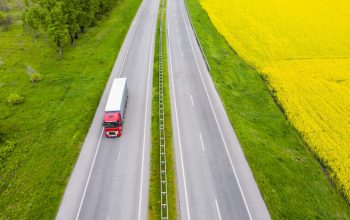 Aerial view of a truck on the highway at sunset. Shipping and delivery