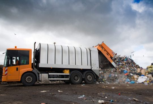 landfill pollutes the environment. garbage truck. birds fly over landfill